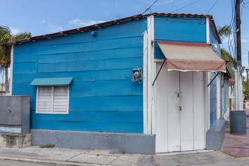 Fototapeta na wymiar Empty streets, people stay inside their home. Wooden colorful house in Mexico. Siesta time is a must, especially during summer afternoons. 
