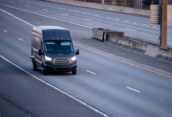 Black cargo mini van running on the multiline road