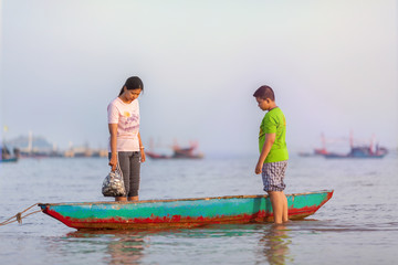 mother and boy standing at the green boat.selective focus.