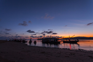 Obraz premium The coastal fishing boats parked on the beach at sunset.silhouette.selective focus.