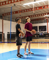 Fototapeta premium Teenage boys holding basketball on the court team and aspiration concept