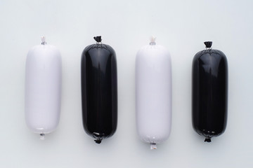 Food composition of black and white sausages in a strict laconic style. Top view.