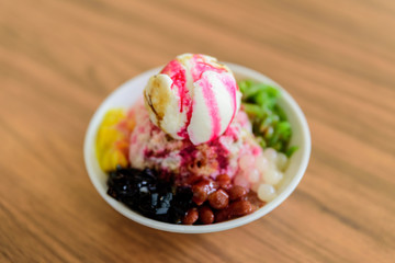 Soft focus of Ais Kacang topped with basil seeds, peanuts, corn, and a scoop of ice cream. Ice kacang meaning bean ice, also known as ABC is a Malaysian, Singapore, Brunei dessert.