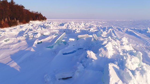 Low aerial flight over scenic, surreal jagged ice shoves on the shore of Door County Wisconsin, created by high winds in Springtime.