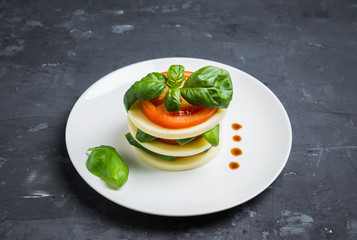 Salad Caprese with mozzarella and tomato. Layers served. Selective focus.