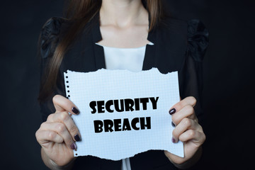 In the hands of a businessman a scrap of paper with the inscription:SECURITY BREACH