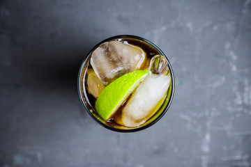 Cuba libre cocktail on the rustic background. Selective focus.