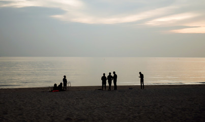 Fototapeta na wymiar People stood watching the sea, Sunrise and happy 