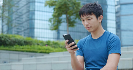 Asian man using cellphone to send sms