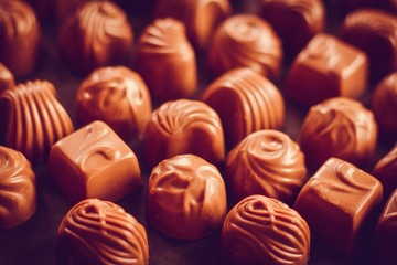 Many different chocolate candy lie on the table. Assortment of chocolate.