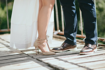 the bride and groom posing on a suspension bridge. feet close-up