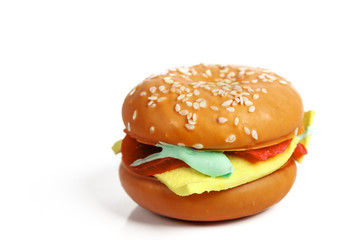 a cake resembling a hamburger isolated on white background closeup