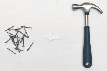 Hammer and nails on white wooden board surface background with copy space. Construction concept background.