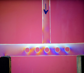A force of 50 Newton is added from above (indicated by arrow) to a transparent balk with holes....