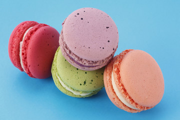 Sweet and colorful French macarons on blue background