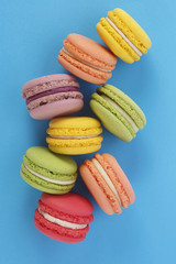 Assorted colorful french cookies macaroons. Almond cookies on blue background. Top view.