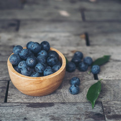 Fresh plums  in wooden bowl on old wooden background