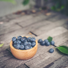 Fresh plums  in wooden bowl on old wooden background
