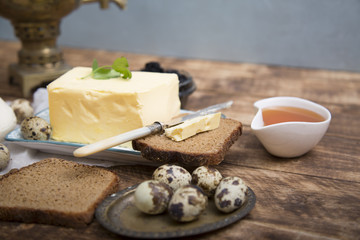Breakfast table with bread slice, butter, black caviar, milk and honey 