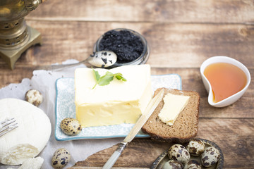 Breakfast table with bread slice, butter, black caviar, milk and honey 