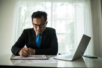 Young businessman working with laptop at office