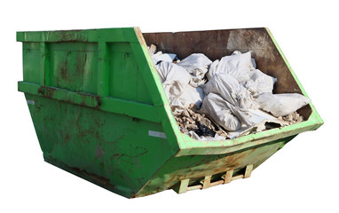 Crushed rusty green container filled with construction debris