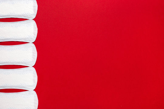 Menstruation, protection means. Row of white pantyliners on red background