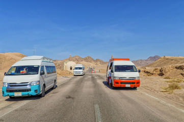 entrance to Ras Mohamed National Park in Egypt, asphalt road, desert landscape, minibuses, buildings, against a blue sky without a cloudy sky