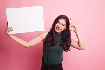 Young Asian woman show OK with  white blank sign.