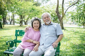 healthy senior couple relaxing seats on Chair in the park