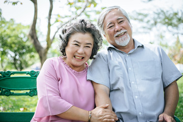 Obraz premium healthy senior couple relaxing seats on Chair in the park