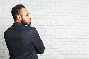 Young fashionable men in a suit against brick wall