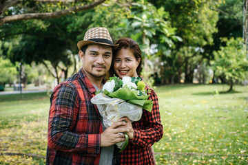 Close-up of a man giving happy woman flowers.A picture of a romantic couple getting.