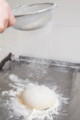 cook sifts the flour for the dough