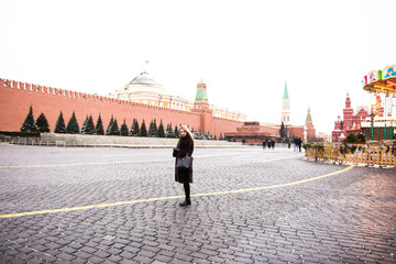 Portrait in full growth, Russian beautiful woman in a mink coat on the Red Square in Moscow in Christmas time