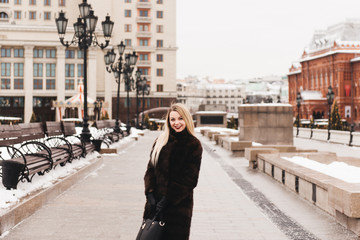Fototapeta premium Portrait in full growth, Russian beautiful woman in a mink coat on the Red Square in Moscow in Christmas time