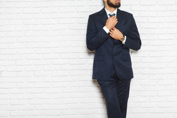 Young fashionable men in a suit against brick wall