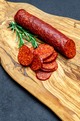 Dried organic salami sausage on wooden cutting board