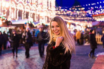 Portrait in full growth, Russian beautiful woman in a mink coat on the Red Square in Moscow in Christmas time