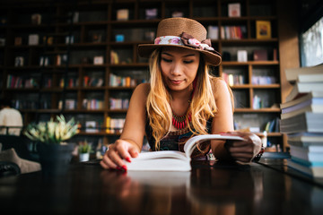 Young woman  reading book and fresh cup of coffee on the table