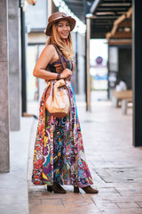 The woman is walking on the street with great smile.