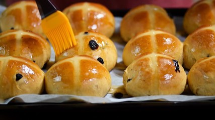 Homemade Easter traditional hot cross buns. Female hands cover with syrup - Powered by Adobe