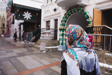 Fototapeta premium A young beautiful girl in a mink coat and a Russian folk scarf walks around the Izmailovo Kremlin. Moscow, Russia.