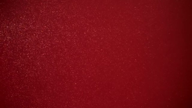 Slow moving real particles on red background