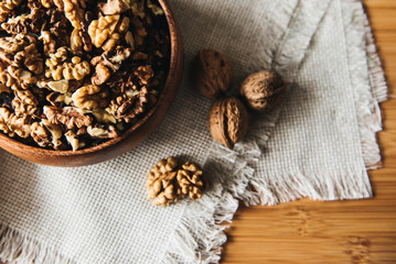 Walnuts kernels in wood bowl on dark desk, Walnut with color background, Whole walnuts in wood vintage bowl. rustic