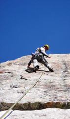 mountain guide rock climber on a steep granite route in the Alps of Switzerland on a beautiful day