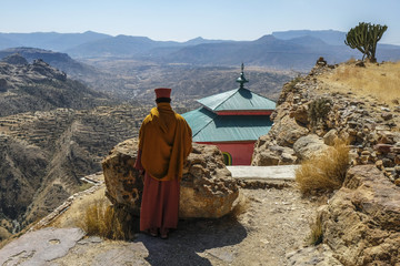 Priest looking over scarp at monastery Debre Damo, near Adigrat in Tigray Region, Ethiopia.