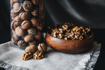 Walnuts kernels in wood bowl on dark desk, Walnut with color background, Whole walnuts in wood vintage bowl. rustic