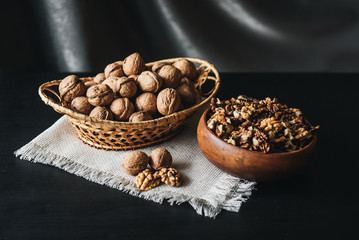 Walnuts kernels in wood bowl on dark desk, Walnut with color background, Whole walnuts in wood vintage bowl. rustic