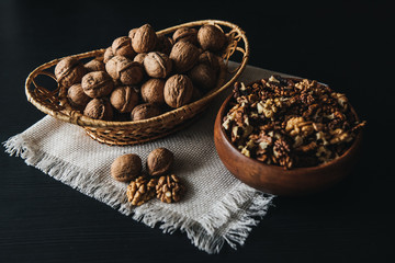 Walnuts kernels in wood bowl on dark desk, Walnut with color background, Whole walnuts in wood vintage bowl. rustic